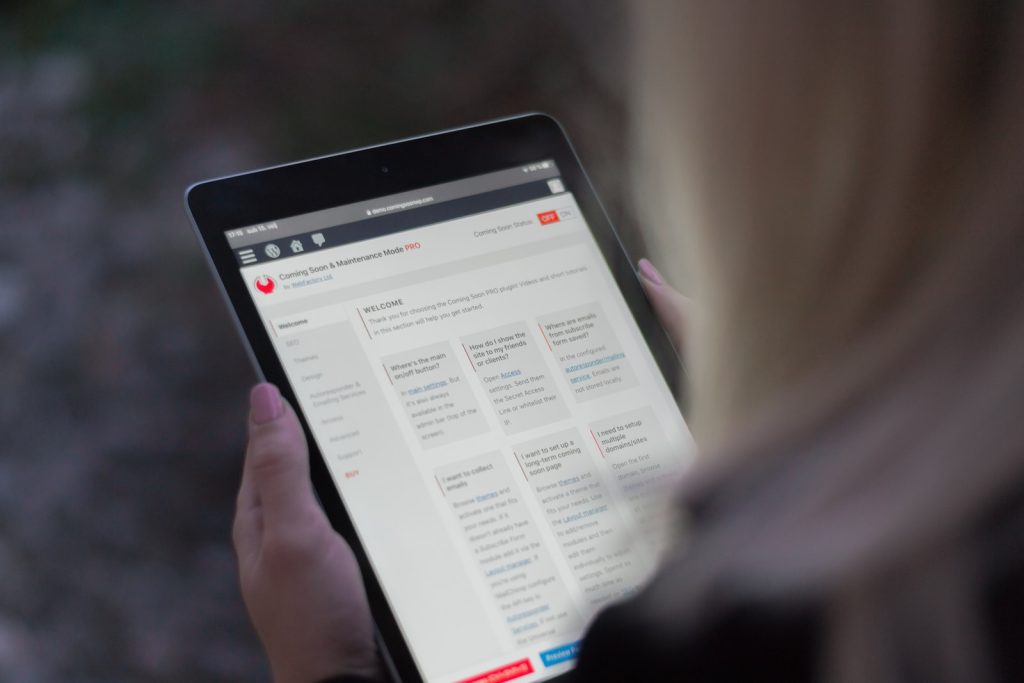personne tenant une tablette électronique noire