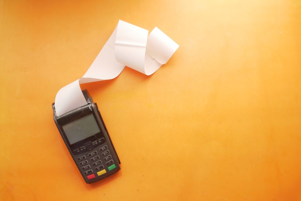 un téléphone portable posé sur une table à côté d'un rouleau de papier